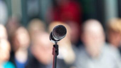 Microphone in focus against blurred group of people