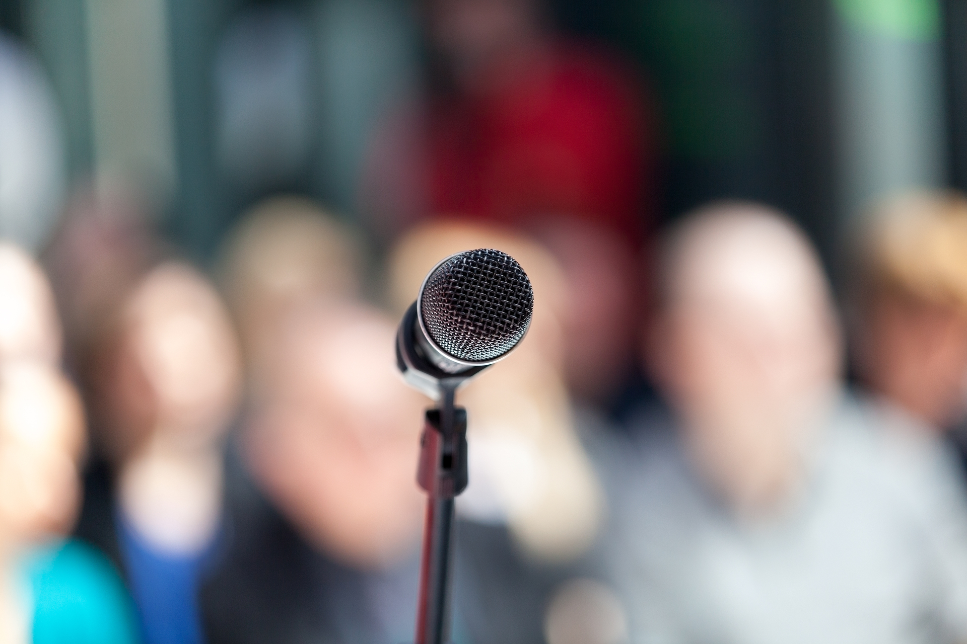 Microphone in focus against blurred group of people